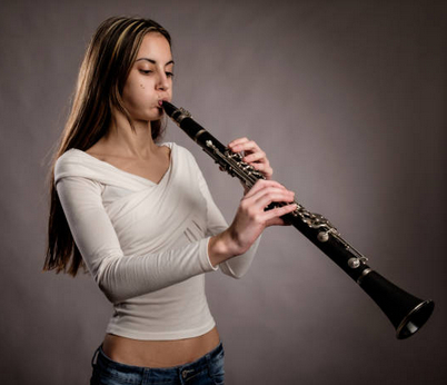 Une clarinettiste qui essaie de jouer sans anche et en gonflant les joues
